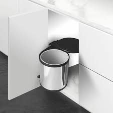 Round stainless steel pull-out dustbin inside a white kitchen cabinet