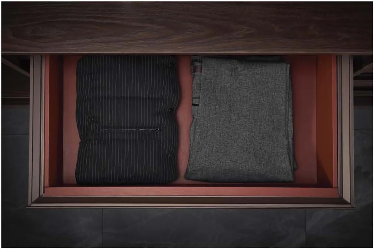 Leather storage basket with folded sweaters in a wardrobe