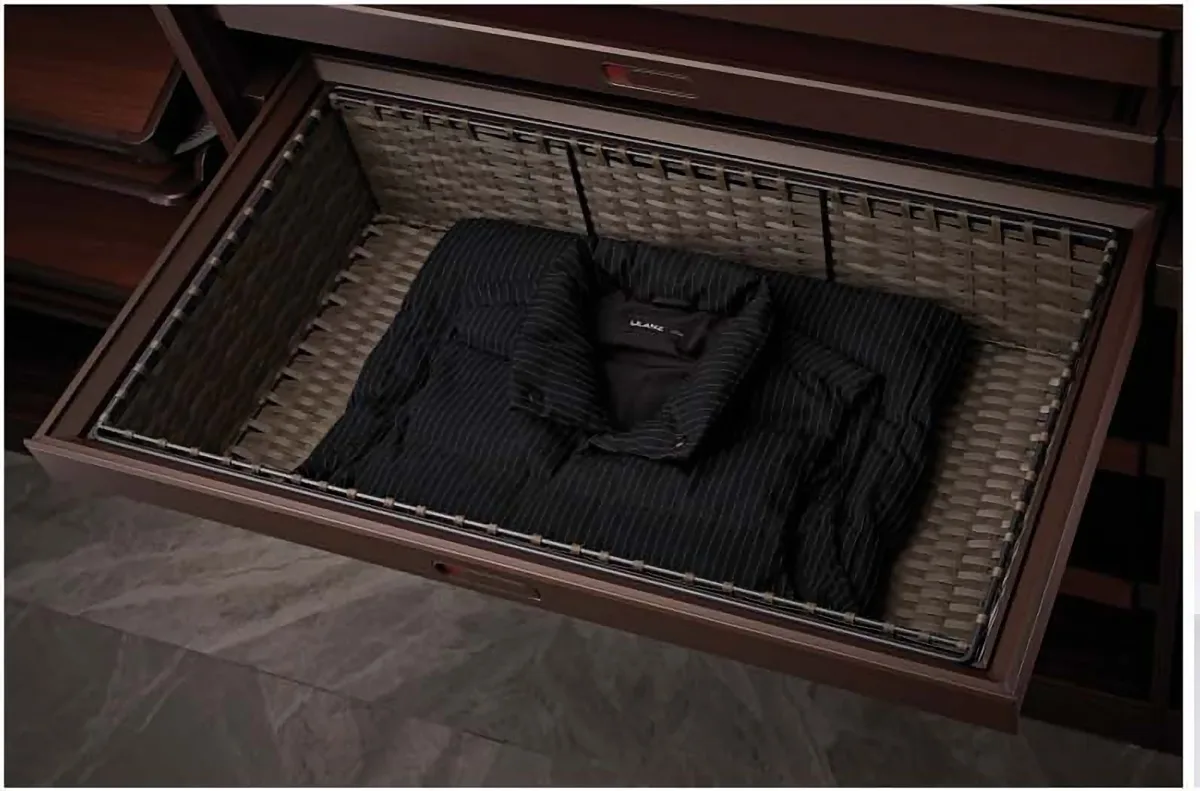 Rattan pull-out basket holding folded clothes in a wardrobe